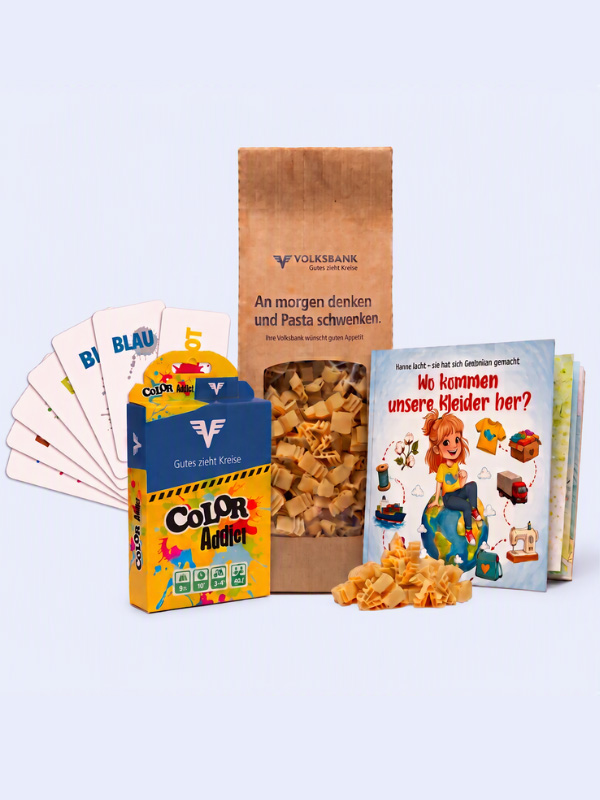 Ein Überblick über die Weltspartags-Geschenke der Volksbank: Man sieht ein Kartenspiel, Nudeln und ein Kinderbuch.